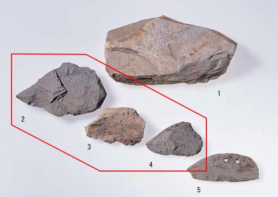 1が流紋岩原石、2から4が流紋岩石庖丁の未成品、5が流紋岩石庖丁で、2、3、4が赤枠で囲まれている写真