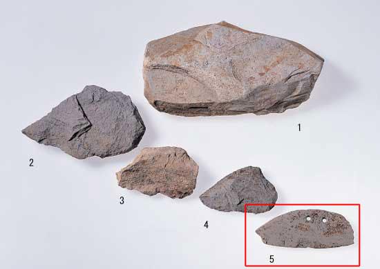 1が流紋岩原石、2から4が流紋岩石庖丁の未成品、5が流紋岩石庖丁で5が赤枠で囲まれている写真
