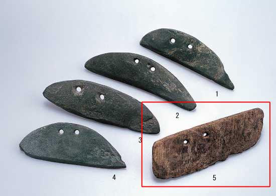4つの石庖丁と1つの木製穂摘具があり、1から5まで番号がふられ、5の木製穂摘具のみ赤枠で囲まれている写真