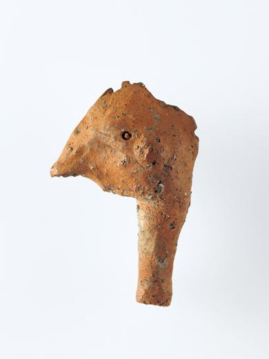 鶏頭形の土製品の写真。頭頂部の鶏冠の表現や嘴など、非常に写実的なもの。